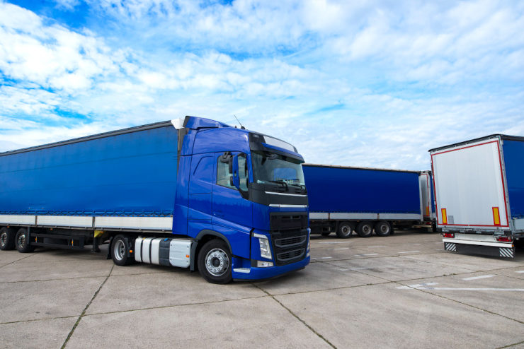 Três caminhões azuis representando uma transportadora