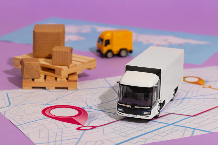 Imagem representando uma cadeia de suprimentos, com mapa, caminhão e cargas para transporte