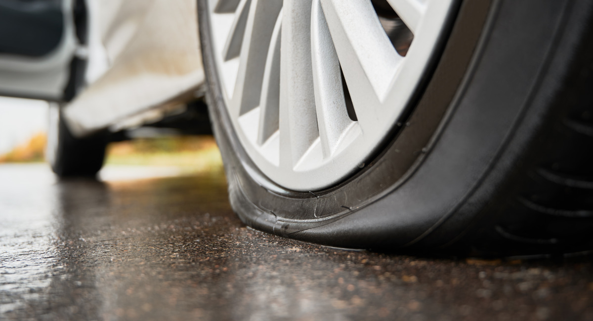 pneu de carro furado em um asfalto