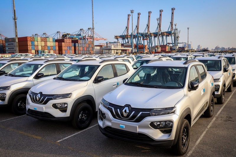 frota de Renault Kwid E-tech em um porto, com containers ao fundo